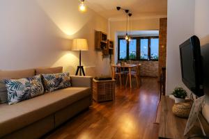 a living room with a couch and a television at Aquele Cantinho in Amadora