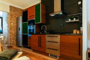 una cucina con mobili in legno e un frigorifero in acciaio inossidabile di Aquele Cantinho ad Amadora Altre 5 foto