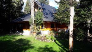 una casa de madera con un poste delante en Casa de La Montaña, en Villa La Angostura