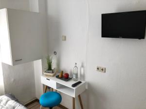 a room with a white table and a tv on a wall at Downtown City - PrivateRooms in Fürth