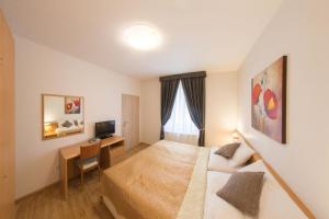 una habitación de hotel con una cama y un escritorio en Salvator Superior Apartments, en Praga