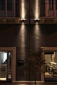 a building with a tree in front of a building with lights at Locanda del Bagatto in Milazzo