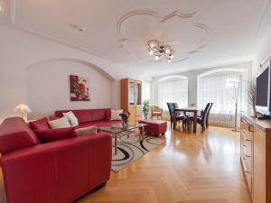 リンダウにあるFerienwohnungen Henslerのリビングルーム(赤いソファ、テーブル付)
