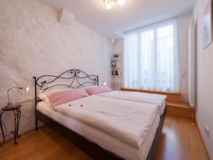 Dormitorio con cama con marco negro y ventana en Ferienwohnungen Hensler en Lindau