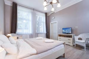 a bedroom with a large bed and a tv at Elegant Apartments in Krakow
