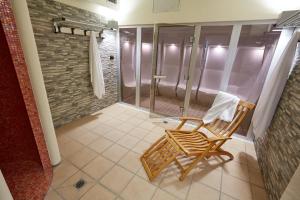 La salle de bains est pourvue d'une douche et d'un fauteuil à bascule. dans l'établissement Liberty Hotel, à Turin