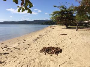 a bunch of footprints in the sand on a beach at Flats Paraty in Paraty
