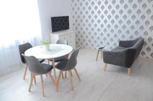 ein Esszimmer mit einem weißen Tisch und Stühlen in der Unterkunft Multi Apartment Łąkowa 18/13 in Białystok