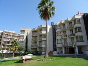 a boat and a palm tree in front of a building at AR Bolero park in Lloret de Mar