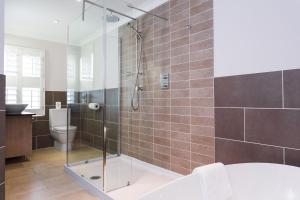 a bathroom with a shower with a tub and a toilet at The Beach in Bude