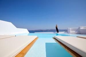 a person standing on the edge of a swimming pool at Phos The Boutique in Akrotiri