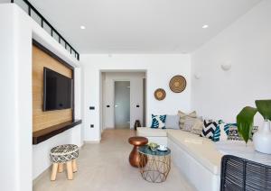 a living room with a couch and a tv at Phos The Boutique in Akrotiri
