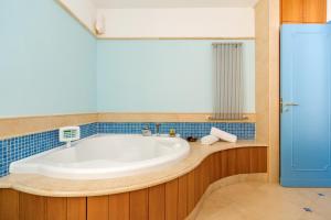 a bath tub in a bathroom with blue tiles at Villa Araucaria in Ischia