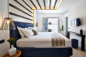 a bedroom with a large bed with a blue headboard at Phos The Boutique in Akrotiri