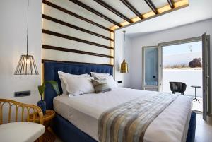 a bedroom with a large bed with a blue headboard at Phos The Boutique in Akrotiri