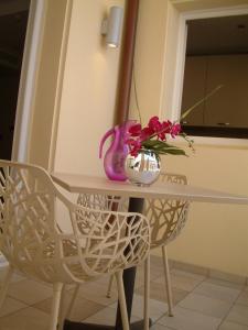 a table with a vase and flowers on it at Hotel Villa d'Elsa in Juan-les-Pins