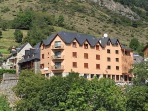 un grand bâtiment avec une montagne en arrière-plan dans l'établissement Pension Malida, à Casau