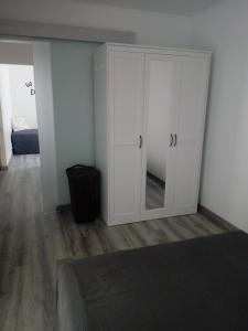 a bedroom with a large white cabinet with a mirror at Jazmines in Santiago de la Ribera