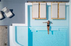 una mujer en bikini entrando en una piscina en Phos The Boutique en Akrotiri