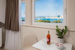 Una botella de vino en una mesa en una cocina con ventana en Mediterra Residence, en Split