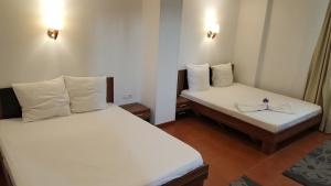 two beds in a small room with white sheets at Hotel Viva in Ploieşti