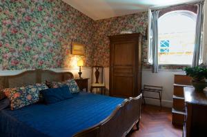 a bedroom with a blue bed and floral wallpaper at Guest House Arco Dei Tolomei in Rome