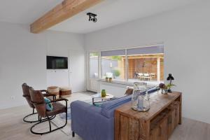 a living room with a blue couch and a table at Banjaard Beachhouse Patrijzenlaan 14 in Kamperland