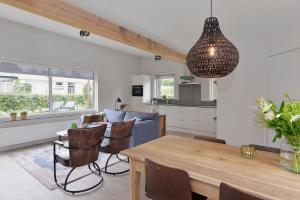 een keuken en een woonkamer met een houten tafel en stoelen bij Banjaard Beachhouse Patrijzenlaan 14 in Kamperland
