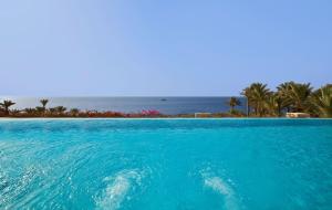 een zwembad met de oceaan op de achtergrond bij Grand Rotana Resort & Spa in Sharm El Sheikh