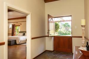 1 dormitorio con cama y ventana en The Country Guesthouse, en Stellenbosch
