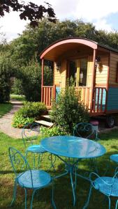 a table and chairs in front of a house at Roulotte Gabi in Rouville