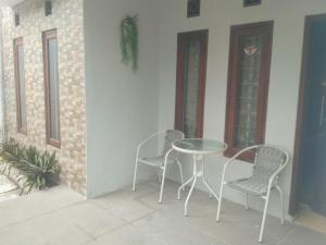 two chairs and a table on a patio at Homestay Bumi Asri III Cikutra in Bandung