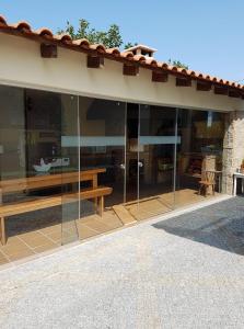 Casa da Ribeira في أفيرو: بيت زجاجي مع طاولة خشبية ومقعد