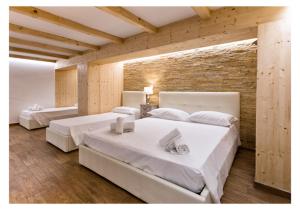 a bedroom with two beds and a brick wall at Ludovica's Apartment in Termoli