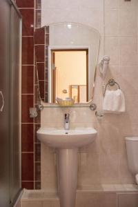 La salle de bains est pourvue d'un lavabo et d'un miroir. dans l'établissement Metelitsa Hotel, à Sourgout