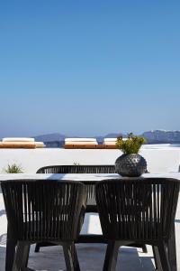 a table with two chairs and a vase on it at Phos The Boutique in Akrotiri