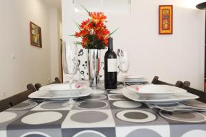 een tafel met een fles wijn en een vaas met bloemen bij Bonito apartamento con barbacoa in Benalmádena