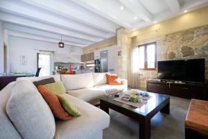 uma sala de estar com um sofá branco e uma mesa em Iridanos Villa em Kissamos