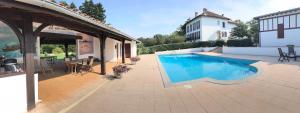 a swimming pool in a yard next to a building at Beltzenia Txoko in Urrugne