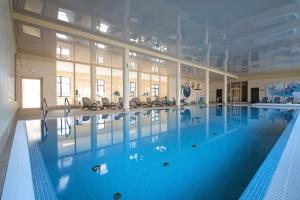 a large indoor swimming pool with blue water at Hotel Kawallo in Słubice