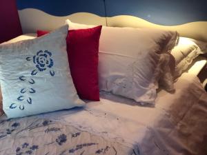 a bed with four pillows on top of it at Guest House By Rose in Olgiate Olona