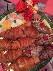 a plate of pastries on a table with roses at Guest House By Rose in Olgiate Olona