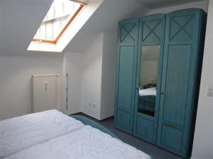 ツィングストにあるVilla Nadine, gemütliche Ferienwohnungのベッドルーム1室(ベッドの横に青いキャビネット付)