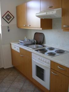 a kitchen with a stove and a sink at Villa Nadine, gemütliche Ferienwohnung in Zingst