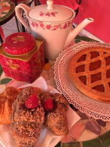 stół z talerzem wypieków i filiżanką kawy w obiekcie Guest House By Rose w mieście Olgiate Olona