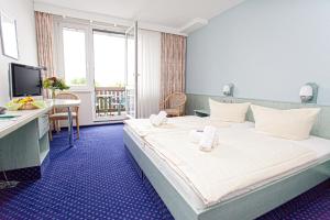une chambre d'hôtel avec un grand lit et des serviettes. dans l'établissement WAGNERS Sporthotel Oberhof, à Oberhof