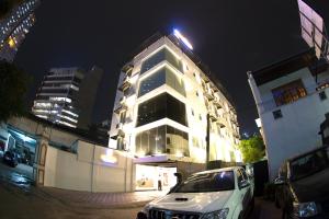 un coche blanco estacionado frente a un edificio por la noche en City Hotel Colombo 02, en Colombo