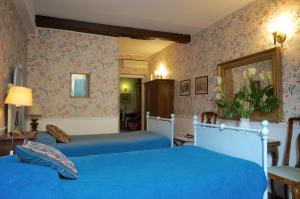 a bedroom with two blue beds and floral wallpaper at Guest House Arco Dei Tolomei in Rome