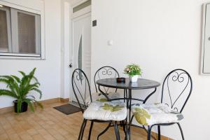 uma mesa e cadeiras num quarto com uma planta em Apartman 1 em Zadar