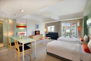 a hotel room with a bed and a table and a desk at HARRIS Hotel & Residences Riverview Kuta, Bali - Associated HARRIS in Kuta